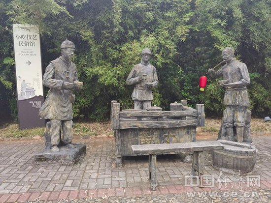俞邦村内的雕塑，呈现了沙县人最早外出摆摊创业的情形。（中国经济网记者 王岩/摄）