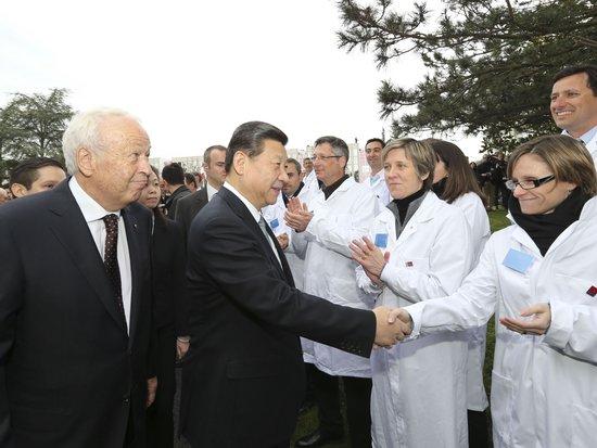 2014年3月26日，习近平主席在法国里昂参观梅里埃生物科研中心，与科研中心员工握手。
