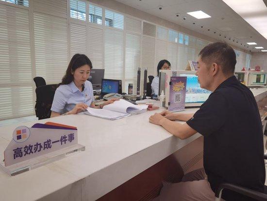  7月17日，在天津滨海新区政务服务中心“高效办成一件事”专区，企业负责人正在提交申请材料。新华社记者杨文 摄