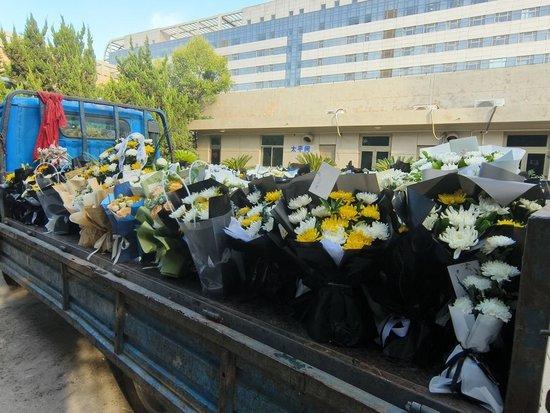 附一医太平间前，一辆货车装满了悼念李晟医生的花束 周昱帆 摄