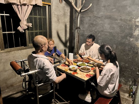  长江云新闻记者和龙海芬家人边吃边聊