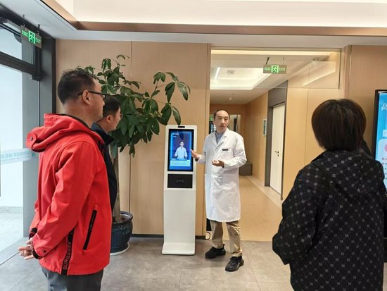 　　2025年1月8日，浙江桐乡乌镇智能医院执行院长沈帆在向患者介绍智能导诊机器人。（郑世杰 摄）