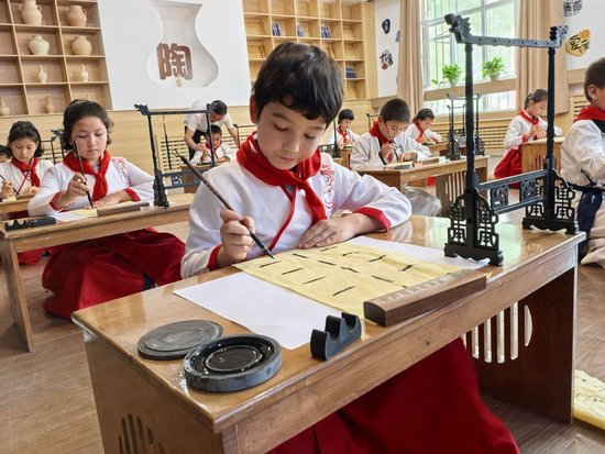  6月26日，在泰安市对口支援的岳普湖县艾西曼镇一小学内，孩子们正在学习书法。（新华社记者 顾煜 摄）