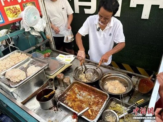  “鸡排哥”李俊永正在为食客炸制鸡排。记者 李韵涵 摄