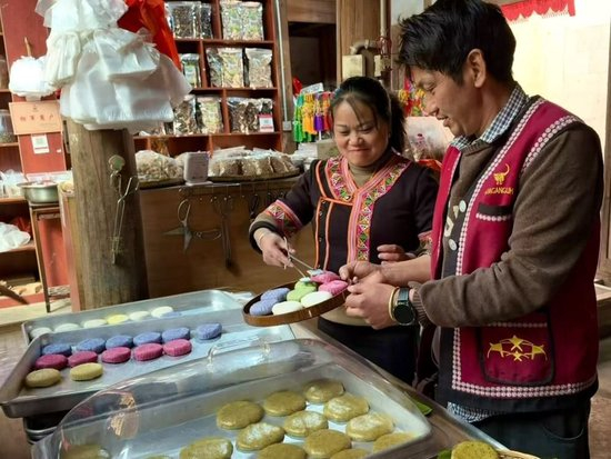  2026年1月27日，云南省腾冲市清水镇司莫拉佤族村村民李发顺夫妇正在为游客打包大米粑粑。新华社记者 熊轩昂 摄