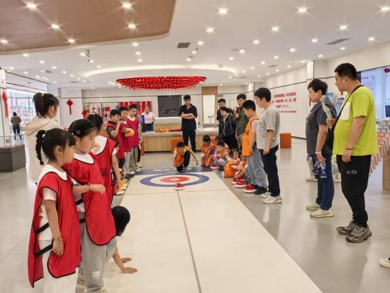孩子们在辽宁省沈阳市长安社区党群服务中心参加旱地冰壶学习活动。（受访者供图）