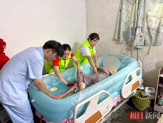 蔡苗苗、暴福清和刘海驰正进行助浴服务