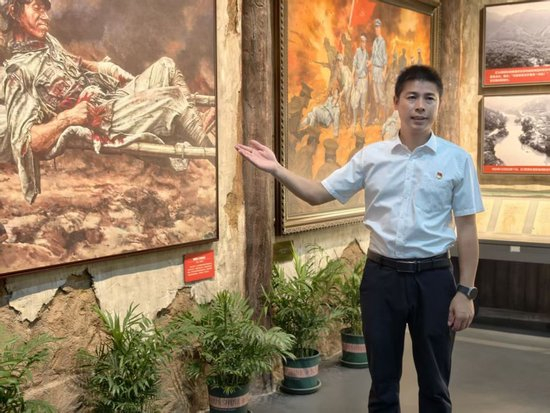 8月20日，在广西桂林全州县红军长征湘江战役纪念馆，周运良在油画《陈树湘》前讲解。（新华社发）