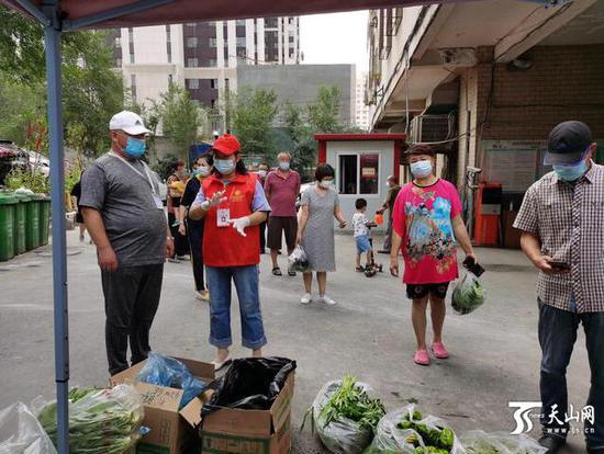  乌鲁木齐高新区（新市区）高新街街道桂林路社区居民在临时便民蔬菜销售点买平价菜。