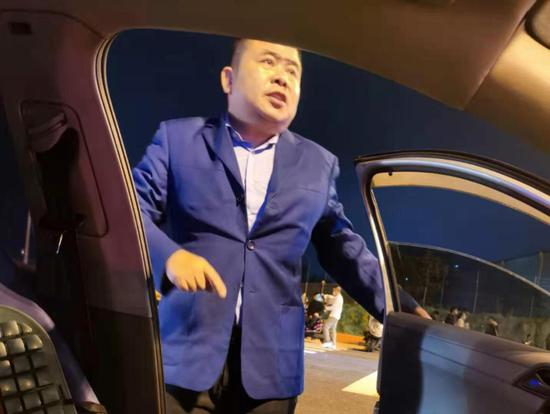  在殡仪馆门口义务接送乘客的出租车司机蔡小强。 雷册渊 摄