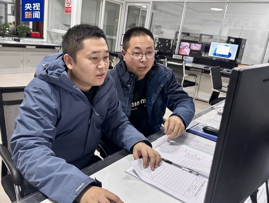 △杨飞鸿（左）与王俊杰（右）查看春运气象数据