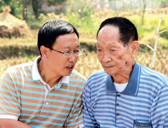 ·2014年10月10日，袁隆平与邓启云在田边交流。