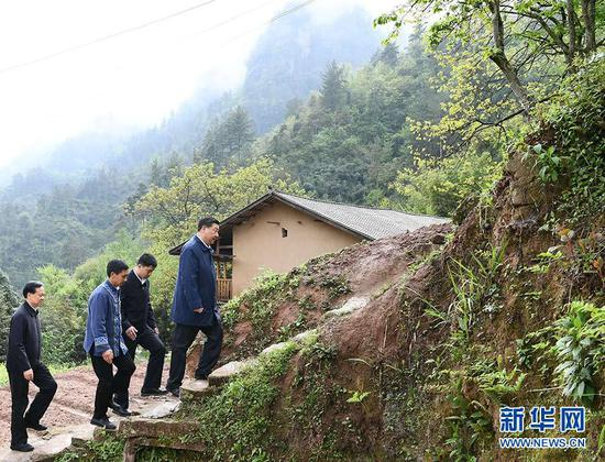  2019年4月15日，在重庆石柱土家族自治县中益乡华溪村，习近平踏着湿滑的石阶登上陡坡，前往贫困户谭登周家看望。新华社记者 谢环驰 摄