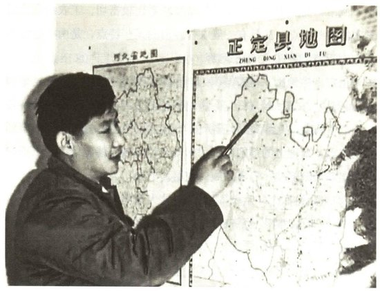  △习近平在办公室地图前谋划正定的发展。