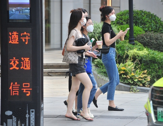 　　7月12日，上海，当天是申城今夏以来的第八个高温日。早晨8点上海中心气象台就发布了高温黄色预警，街头热浪袭人，酷暑难耐。路人打着遮阳伞步履匆匆，女士们手持降温饮料逛街。IC 图