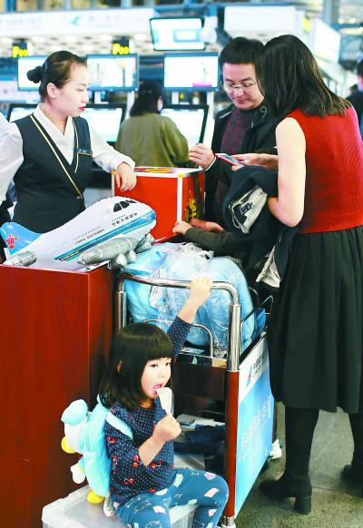 南航工作人员在T2航站楼值机厅为旅客现场办理相关业务，答疑解惑。