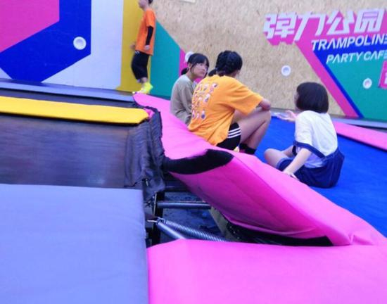 蹦床边框处翘起一角，漏出弹簧，存在着安全隐患