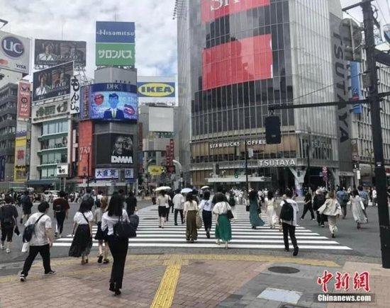 资料图：日本民众穿过涩谷车站前的交叉路口。中新社记者 吕少威 摄