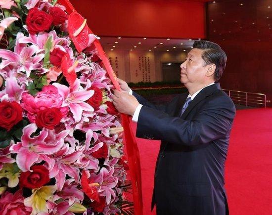 2014年9月3日上午,在向抗战烈士敬献花篮仪式上,习近平整理花篮上的缎带。