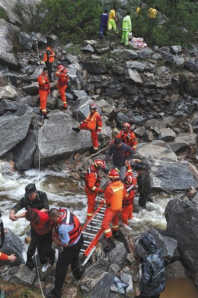 7月16日，密云琉辛路某段，救援人员将被困游客转移出危险地带。