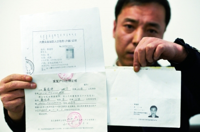 薛福祥向记者展示自己手中的身份证，以及由内蒙古警方出具的户口注销证明。摄/记者刘畅