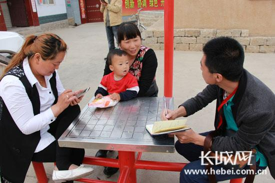 在顾家台圆梦广场，当地村民接受记者采访。长城网 赵晓慧 摄