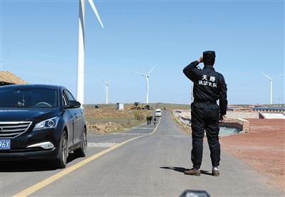 　　10日上午，张北草原天路服务中心，一名身穿“天路执法大队”字样服装的男子站在道路中间拦停路过车辆，告诉乘客需要按人头买票方可通过天路。新京报记者 吴江 摄