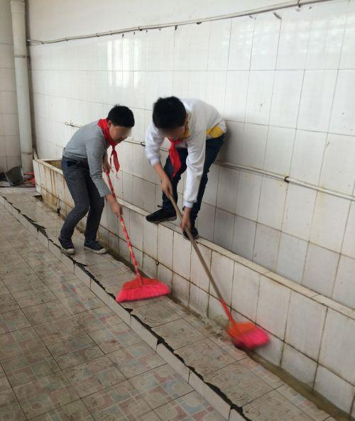 小学让学生扫厕所，图为学生清洁当时