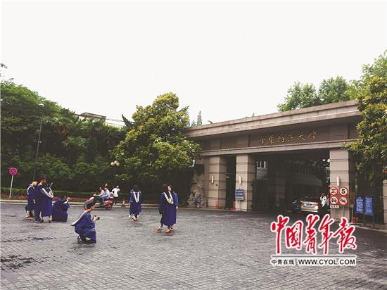 　　5月29日，穿着蓝色学位服的硕士生在华东理工大学徐汇校区门口拍照。中国青年报·中青在线记者 李雅娟/摄