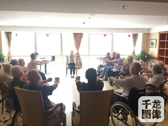 　　今年5月初，江淑一组织了“快乐一小时”的活动，该活动以音乐为载体，旨在观察失能老人在认知、情绪、社交等方面的表现。图为江淑一引导老人做“音乐辅疗” 。受访人供图