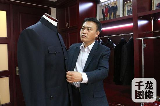 在高黎明手中，一块布料经过裁剪，很快就要变成精美的成衣。千龙网记者 马文娟摄