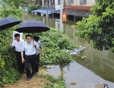 5日，李克强手举雨伞，徒步走在岳阳内涝城中村察看汛情。据中国政府网