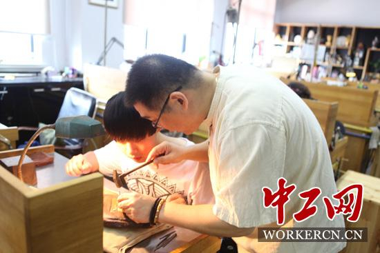 沈国兴正在“手把手”指导徒弟。中工网记者朱晶晶摄