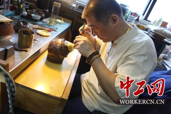 沈国兴正在打磨黄金摆件。中工网记者朱晶晶摄