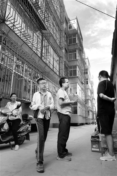 记者（左三）在受害人曾居住的家属区采访。