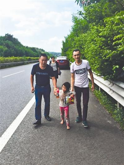 李先生（左）和谭先生帮助小女孩