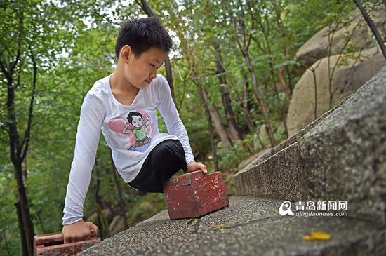 小宇以手代脚，来回倒换着木鞋