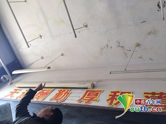 老师指着漏雨教室屋顶给记者看。