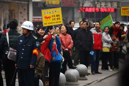 放学的孩子举着某托管中心的牌子