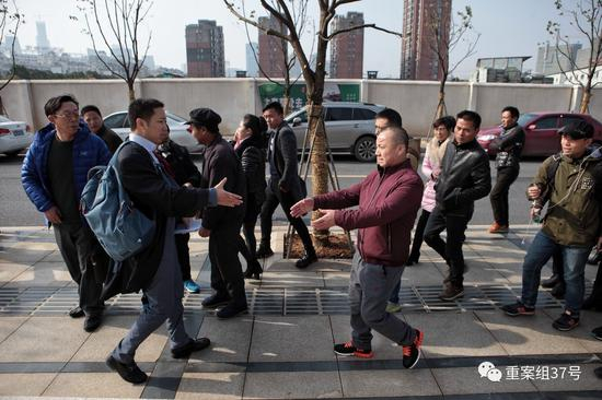 12月22日，被判无罪的黄志强（穿红黑运动鞋者）走出法院和律师握手。&nbsp;&nbsp;&nbsp;&nbsp;新京报记者王嘉宁摄