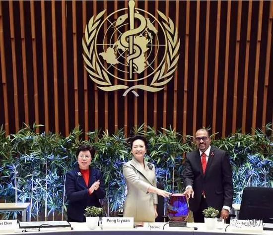 图：联合国艾滋病规划署执行主任西迪贝向彭丽媛颁发艾滋病防治“杰出成就奖”奖杯。