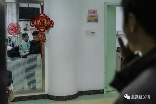 2月21日晚，樊富贵的妻子抱着儿子站在病房窗前与丈夫相望。