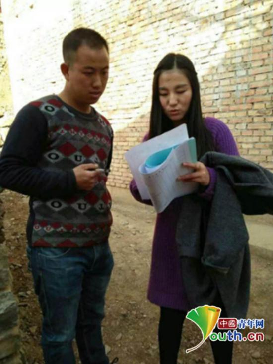 图为王长娥在向农户咨询问题。