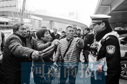 多名“黑停车场”看车人围着前来执法的交警“讨说法”（记者 唐韬/摄）