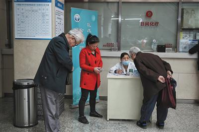 北京大学肿瘤医院，一位老年市民在咨询医药改革新变化。