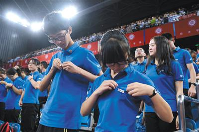 　　2016年9月9日上午，北京大学开学典礼在该校邱德拔体育馆举行，包括本科生、部分研究生在内的约八千学生参加了典礼。图为新生在佩戴校徽。 新京报记者 吴江 摄