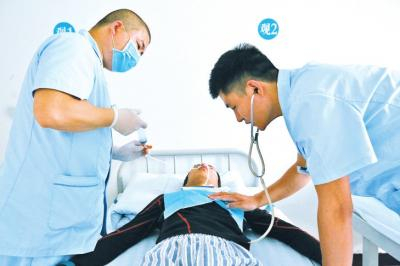 　　一名护士给病人喂食，另一名监测病人的身体状况。