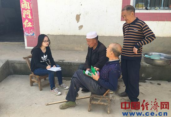 图为经济日报·中国经济网记者李华林（左一）采访贫困户郭邦堂