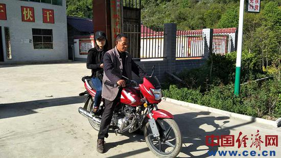图为经济日报·中国经济网记者李华林坐上摩托去采访