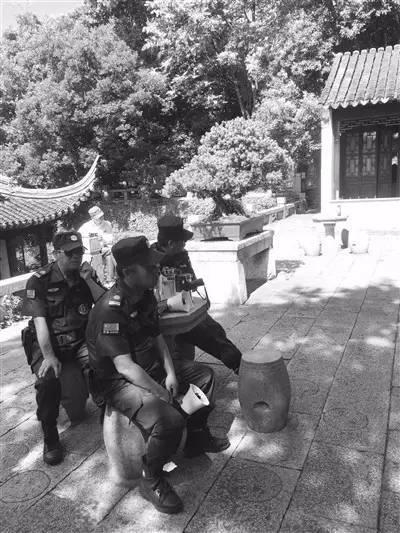景区保安拿着喇叭对着“合唱团”播放“文明公约”。